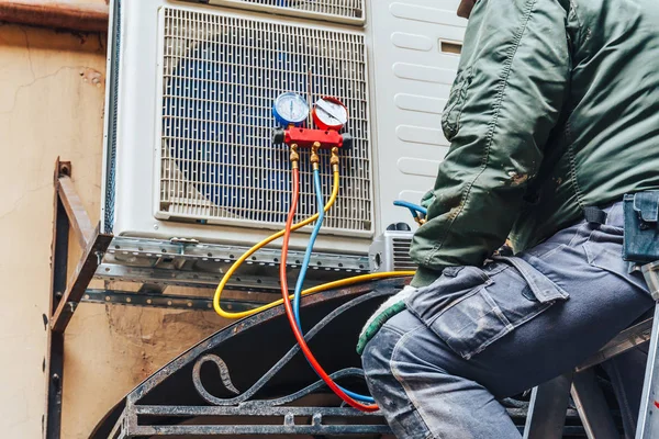 HVAC technician repairing AC unit in Dearborn Michigan