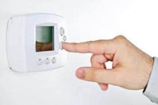 man adjusting thermostat